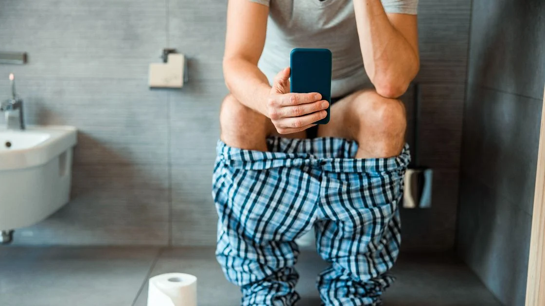 Usar o celular enquanto está no banheiro pode prejudicar sua saúde intestinal e o bumbum - Foto: Olena Yakobchuk/Shutterstock